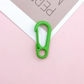 Detailed view of a lime green lobster clasp with spring closure on a pink background - Fruit Green