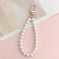 Gros plan sur la chaîne de perles blanches avec fermoir mousqueton doré pour coques - Pendentif Perle Dorée (K262)