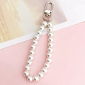 Vue détaillée de la dragonne de téléphone en perles blanches avec fermoir mousqueton argenté - Pendentif Perle Argentée (K828)