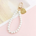 Détail d'un pendentif perles blanches avec cœur doré gravé du logo Mezzo Piano - Pendentif Perle Dorée avec Cœur (K829)