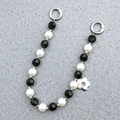 Detail der Perlen-Taschenkette mit schwarzen Facettenperlen und silbernem Blumenanhänger - Perlen Stil (K870)
