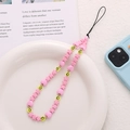 Pink heart and star beaded phone charm with yellow smiley face beads in a white dish - Pink