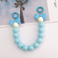 Detail der blauen und beigen Perlenkette aus Acryl mit dekorativen Schleifen und Ringclips - Blau
