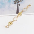 Detailansicht eines glänzenden goldenen Armbands mit unregelmäßigen Gliedern und Magnetverschluss - Gold