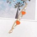 Dettaglio di una doppia catena dorata con cuori in smalto arancione e perle bianche - Modello Magnetico / Arancione