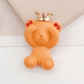 Accessoire ours orange avec couronne dorée et détails en strass rouges sur fond rose - Orange Vitalité