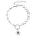 Detail van zilveren paperclip ketting en parelarmband met een ronde M letter hanger - Letter M Stijl