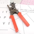 Close-up of rotary leather punch tool with six hole sizes and red non-slip handle - Red and Black (C554)
