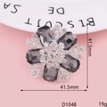 Détail d'une broche fleur avec pierres grises et strass sur un fond de couleur rose - Fleur Strass Argent (D1048)