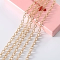 Macro shot of high-polished gold chain links on a pink decorative box for DIY accessories - Meter / Gold Link Chain