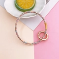 Macro detail of clear resin keychain filled with colorful glitter and gold spring buckle - Colorful