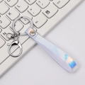 Iridescent laser PVC strap keychain with silver lobster clasp on a white keyboard - White