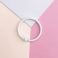Detalle de una anilla de metal blanco para manualidades sobre un fondo geométrico pastel - Anillas de hojas sueltas / Blanco