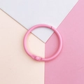 Primer plano del anillo de metal pintado rosa para papelería y tarjetas de bricolaje - Anillas de hojas sueltas / Rosa