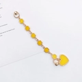 Close-up of a golden alloy chain featuring yellow enamel hearts and hexagonal charms - Yellow