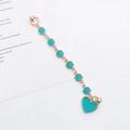 Detail of candy-colored DIY phone strap with gold metal heart charm and turquoise enamel - Blue