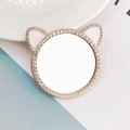 Macro shot of sparkling cat-ear mirror accessory with pink inlay and gold rhinestones - Cat Ear Style / Gold