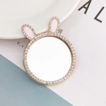 Close-up of a round makeup mirror with pink bunny ears and sparkling crystal rhinestones - Rabbit Ears Style / Gold
