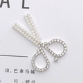 Makroaufnahme des scherenförmigen Legierungs-Accessoires mit Strass und Perlen - Silber