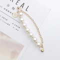 Detail of pearl chain with gold flower pendant on a lifestyle magazine background - Pearl Bracelet with Flower