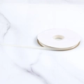 Rollo de cinta de satén de poliéster blanco crema de 1 cm sobre fondo de mármol - Blanco Puro
