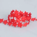 Macro detail of red star-shaped polyester ribbon for festive gift wrapping and decoration - Star Style