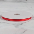 Roll of bright red satin ribbon on a white spool for wedding decor and gift wrapping - High Density Satin Ribbon (0.6cm x 91m)