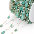 Golden DIY jewelry chain with natural turquoise stones and pearls on a white spool - Green