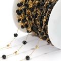 Black faceted beads and gold metal spacers on a chain spool for DIY jewelry making - Black