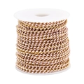 Pink enamel and gold plated stainless steel Cuban link chain on a white spool roll - Pink