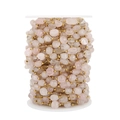 Détail de perles de quartz rose et de billes dorées sur bobine pour création de bijoux - Quartz rose