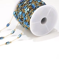 Detail of 1mm gold chain with blue rectangular stones on a white plastic spool - Indigo Blue Chain