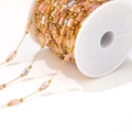 Catena dorata da 1mm con perline cangianti rosa su una bobina di plastica bianca - Catena Colorata Trasparente