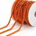 Vibrant orange rhinestone claw chain with gold metal base on a white plastic spool - 3mm / Orange Red