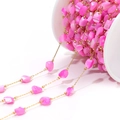 Detail of pink irregular shell beads on gold chain wrapped on a white plastic spool - 4-7mm Irregular Red-Pink Shell Chain