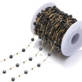 Detalle de cadena de acero inoxidable dorado con cuentas de cristal negro en carrete - Negro (F2093)