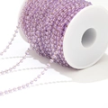 DIY jewelry chain with faceted purple crystals and gold wire on a white spool - Light Purple