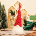 Hanging Christmas gnome with red polka dot hat and white beard in a cozy holiday scene - Red