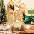 Gnomo di Natale luminoso in peluche con gambe lunghe tra decorazioni natalizie - Cachi