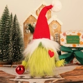 Gnomo di Natale in peluche con pelliccia verde e cuore rosso in ambiente festivo - Stile Braccio Verde