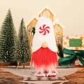 Stehender rot-weißer Weihnachtsgnom mit Zuckerstangenhut und festlicher Dekoration - Runde Süßigkeiten-Stil
