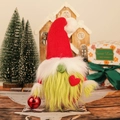Dettaglio di uno gnomo di Natale con barba verde che tiene una palla decorativa rossa festiva - Stile Braccio Rosso