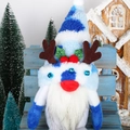Detail of Christmas gnome plush with blue reindeer antlers on a festive wooden bench - Blue