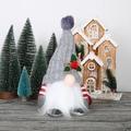 Detalle de un gnomo navideño con gorro de punto y adornos de bayas rojas - Adorno de figura gris brillante