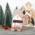 Incantevole gnomo di Natale senza volto in peluche con barba a righe e sfondo festivo - Marrone
