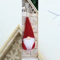 Detail of red Christmas gnome ornament with white beard and knitted hat hanging on wood - Red Polka Dot Style (E)