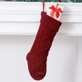 Close-up van dieprode gebreide kerstsok met geschenkdoos bij een witte open haard - Donkerrood