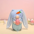 Detalle de gnomo conejo de Pascua con gorro azul sosteniendo un huevo rosa a lunares - Azul
