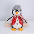 Dettaglio di pinguino di peluche con cappello grigio e sciarpa a quadri natalizia - Pinguino Luminoso con Cappello Grigio