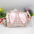 Detailed close-up of pink houndstooth Easter basket with plush bunny ears and pendant - Pink